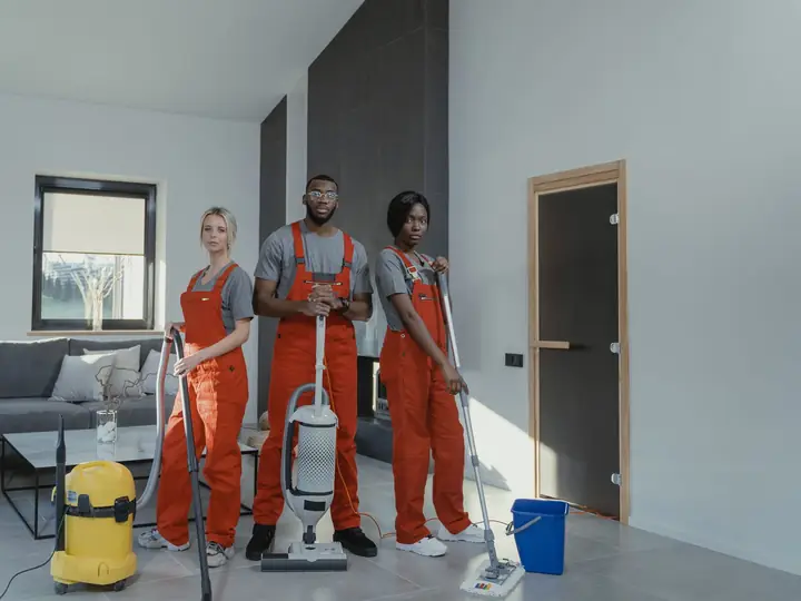 A uniformed cleaning team with vacuum cleaners and cleaning equipment
