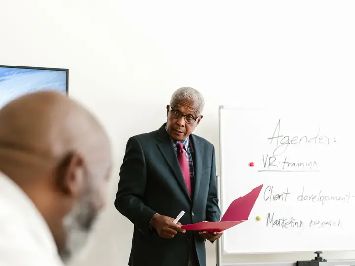 A manager presenting to colleagues in a meeting room