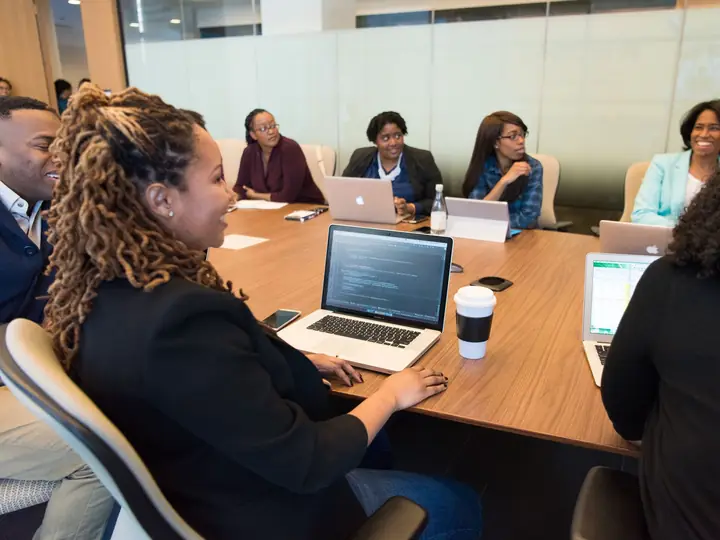 A team planning around a conference table with laptops