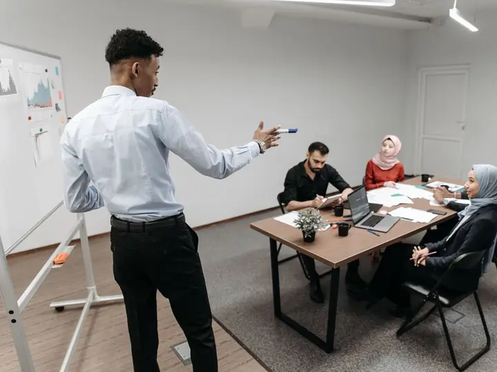 A facilitator leading a training session at a whiteboard